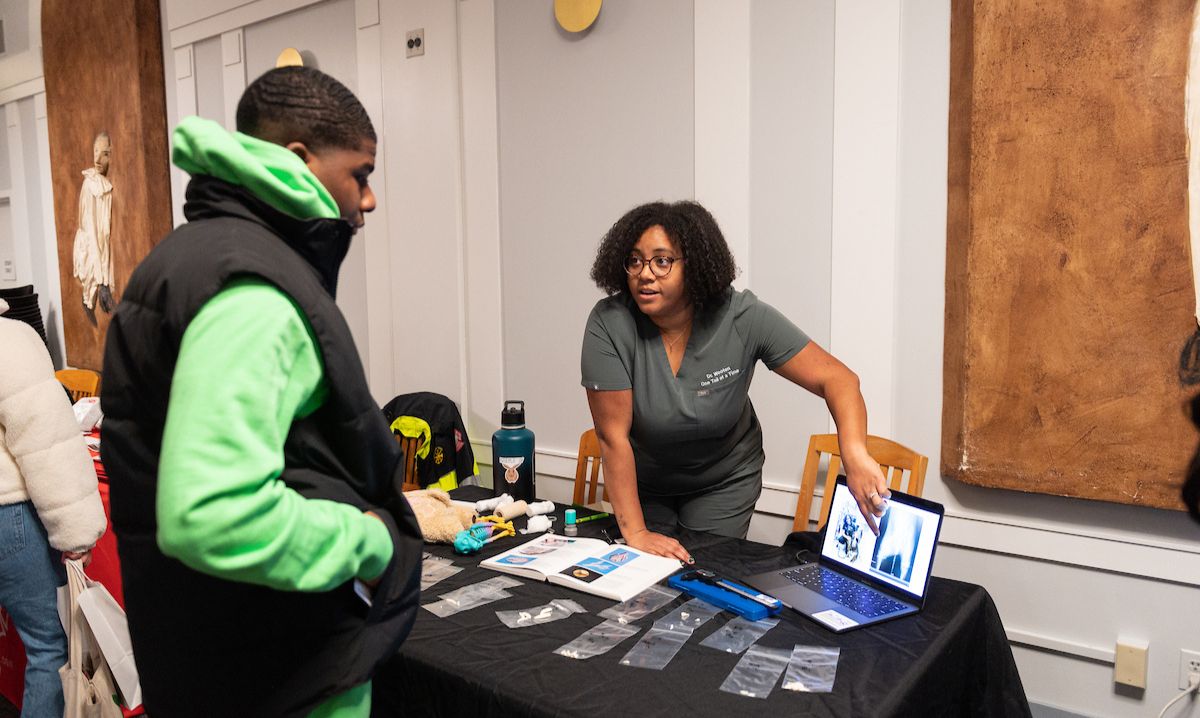 A professional speaking to a teen at the "Design Your Life After High School" career event hosted by the Chicago Public Library, providing guidance and resources for college and career planning.