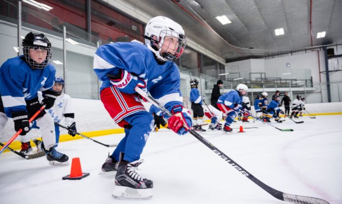 Young hockey players at Canlan Sports Hockey Camp participate in speed and agility drills, improving their skating technique and on-ice performance.